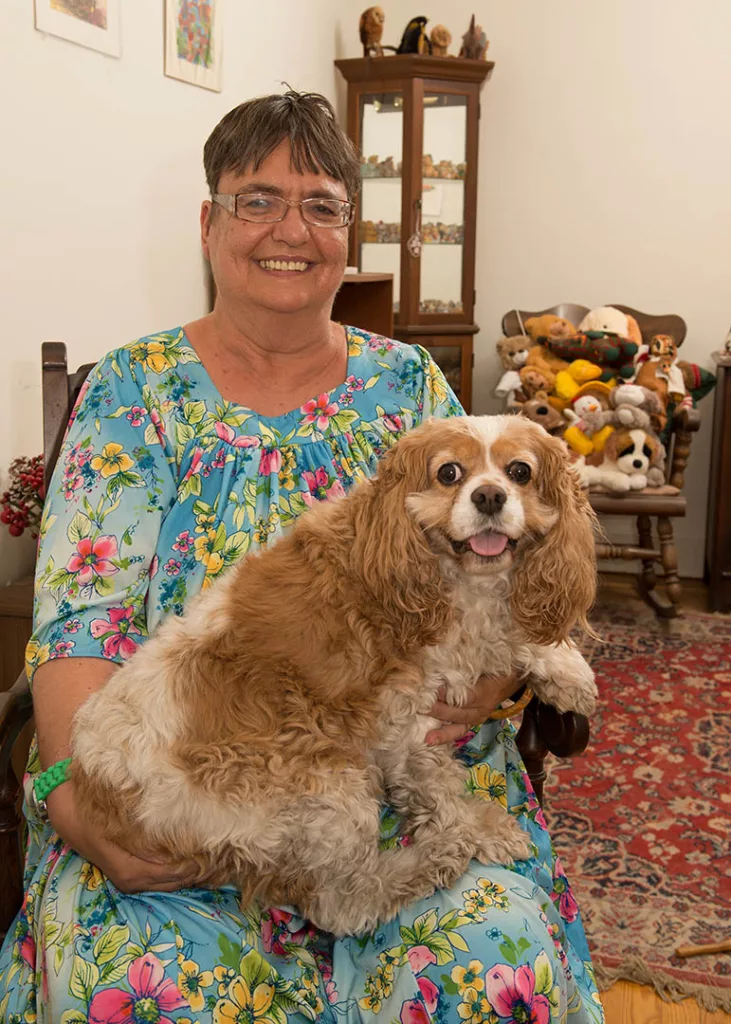 A senior member strokes the head of therapy dog